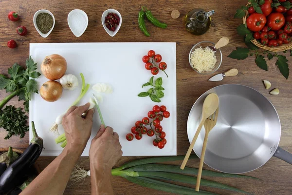 Vista superior de alimentos, las manos cortando cebolla verde en la tabla de cortar blanco —  Fotos de Stock