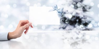 tre Noel zemin üzerine Hediyelik tebrik kartı gösteren el