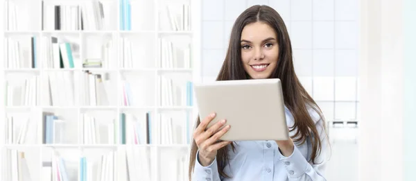 Smiling woman with digital tablet on library background — Stock Photo, Image