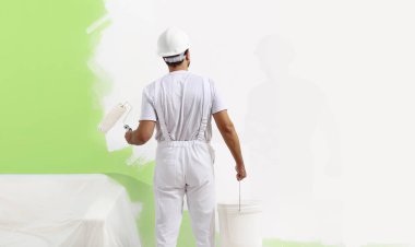ressam adam boya silindiri ile iş yerinde duvar yeşil col boyama