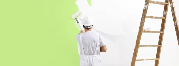 Malíř člověka při práci s Malování válečkem, Nástěnná malba zelené col — Stock fotografie