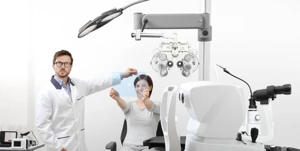 Optometrist examining eyesight woman patient pointing at the hol — Stock Photo, Image