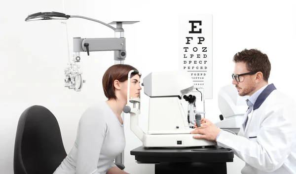 Optometrista examinando paciente de la vista en la oficina del óptico en wh — Foto de Stock