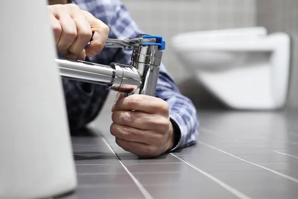 Hands plumber at work in a bathroom, plumbing repair service, as — Stock Photo, Image