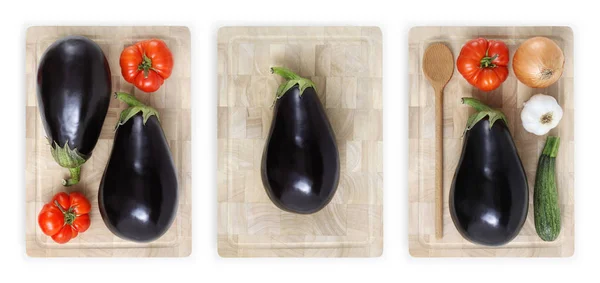 Berenjenas, tomates, calabacín, ajo y cebolla en la cuttina de madera —  Fotos de Stock