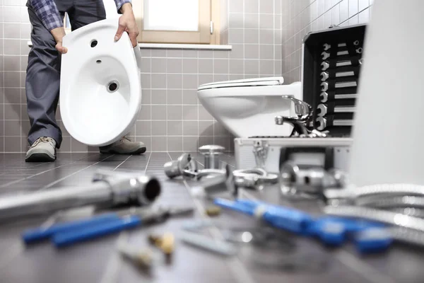 Plumber at work in a bathroom, plumbing repair service, assemble — Stock Photo, Image