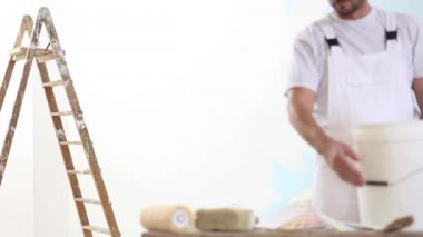 ressam adam işyerinde ile renk renk örnekleri örnekleri, duvar boyama kavramı, merdiven arka plan ve Fırçalar ve kova ön planda
