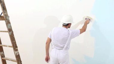 ressam adam fırça, duvar boyama kavramı, beyaz kopyalama alanı arka plan ile iş yerinde