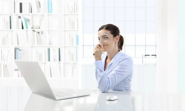 Mulher sorridente de negócios ou um funcionário trabalhando em sua mesa de escritório sagacidade — Fotografia de Stock
