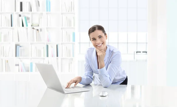 Mujer sonriente de negocios o un empleado que trabaja en el escritorio de su oficina ingenio — Foto de Stock