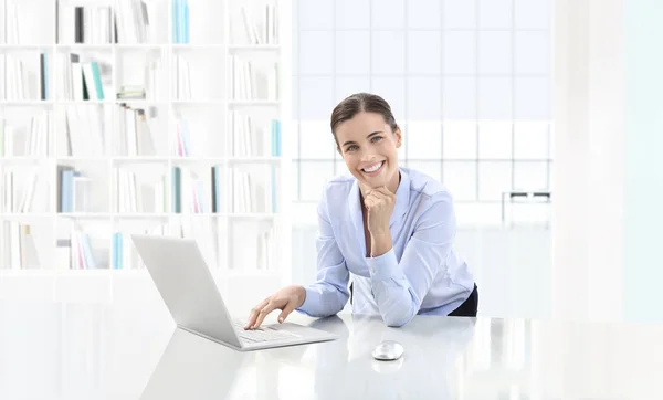 Улыбающаяся деловая женщина или клерк, работающий в ее офисе — стоковое фото