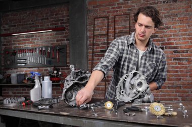 Erkek işi, tamir ve motor parçalarını temizlemek için anahtar seçer. 