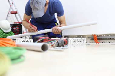 elinde kalem ile iş yerinde elektrikçi plastik pip ölçer