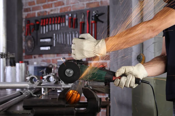 Mãos homem trabalho em casa oficina garagem corte tubo de metal, com contras — Fotografia de Stock