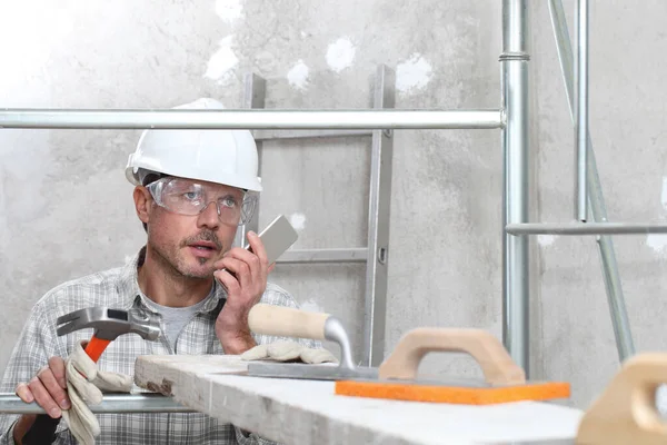 Mann Arbeitet Professioneller Bauarbeiter Mit Handy Putzwerkzeug Auf Baugerüsten Schutzhelm — Stockfoto