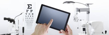 Göz muayenesi konsepti, eller arka planda dijital tablet, oftalmoloji ve optometri ekipmanlarına dokunur