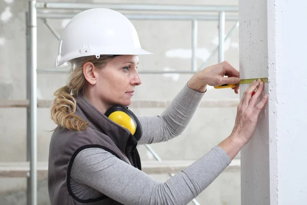 Kvinna Byggnadsarbetare Arbetar Med Meterband Och Penna Mäta Vägg Interiör — Stockfoto