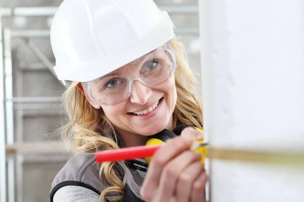 Leende Kvinna Byggnadsarbetare Arbete Med Meterband Och Penna Mäta Vägg — Stockfoto