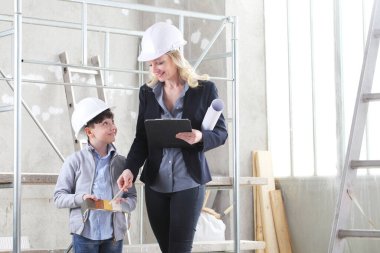 Kadın iç mimar ya da mimar anne ve oğlu işteyken evi dekore etmek için renk kumaşından renkler seçiyorlar.