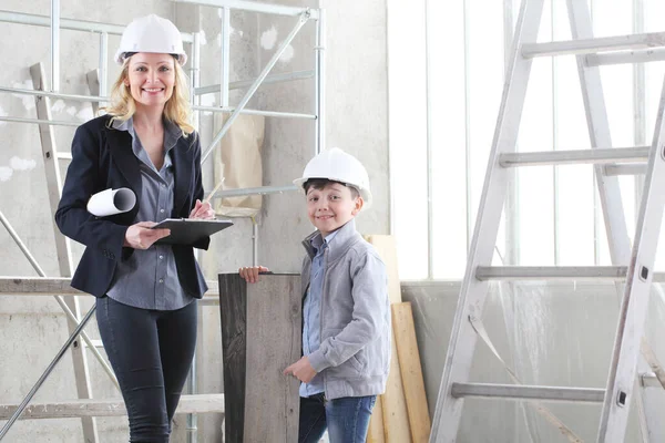 woman interior designer or architect mom with her son at work, they choose how to furnish the house, inside the construction site