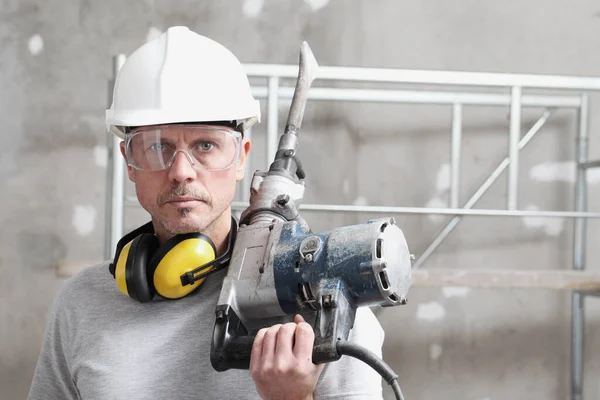Porträtt Manlig Byggnadsarbetare Med Tryckluftsborr Med Säkerhetshårdhatt Hörselskydd Hörlurar Och — Stockfoto