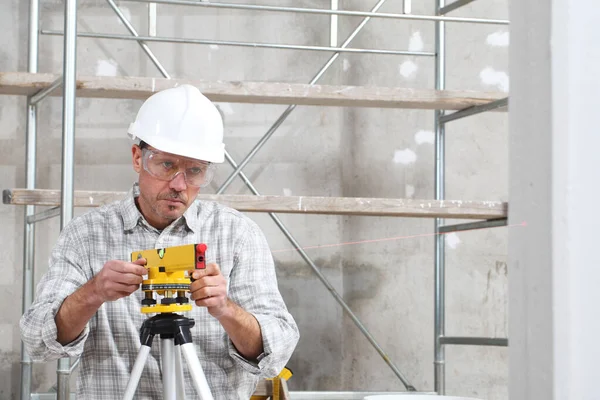 Bauarbeiter Messen Mit Laser Und Schutzbrille Auf Baustelle — Stockfoto