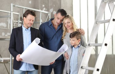 Mimar, çocuklu bir aileye ev tasarımı planlarını gösteriyor. Ev görünümü, iç dekorasyon ve ev düzeni hakkında konuşmak için iç inşaat sahasında buluşacağız.