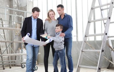 Mimar, çocuklu bir aileye ev tasarımı planlarını gösteriyor. Ev görünümü, iç dekorasyon, ev düzeni ve duvar renkleri hakkında konuşmak için iç inşaat sahasında toplantı.