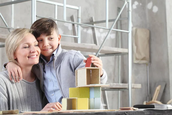 幸せな母親と息子は インテリアサイトで建設モデルと家を建てる再生します 家の購入と建物の目標コンセプト — ストック写真