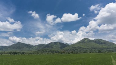 Endonezya 'nın kırsal kesimlerinde mavi gökyüzü ve bulut arka planıyla güzel bir dağ