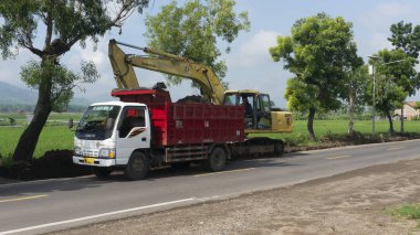 Dünya, Endonezya 'da bir yol yapımında bir buldozerle hareket ediyor. Ponorogo, Endonezya - 18 / 02 / 2020