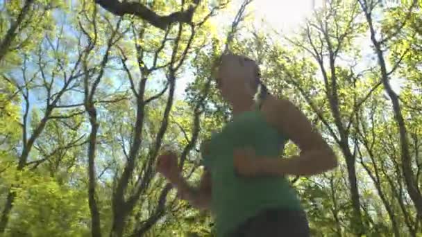 Mujer joven corriendo en el parque de primavera — Vídeos de Stock