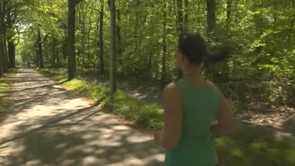 Mujer joven corriendo en el parque de primavera — Vídeos de Stock