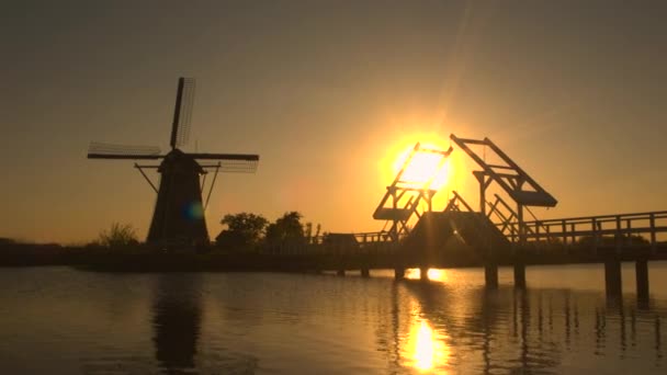 Traditionele windmolen op rivieroever bij zonsondergang — Stockvideo