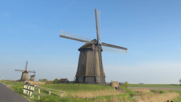 Campo con molinos de viento girando a lo largo del canal — Vídeos de Stock