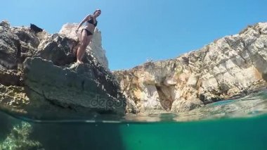 Ağır çekim: genç kadın okyanus sahil tatil yenileme içine atlama