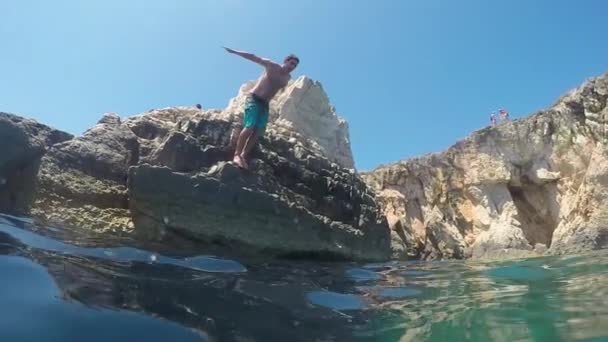 SLOW MOTION SOTTOACQUA: La testa dell'uomo salta in acqua rinfrescante da una scogliera oceanica — Video Stock