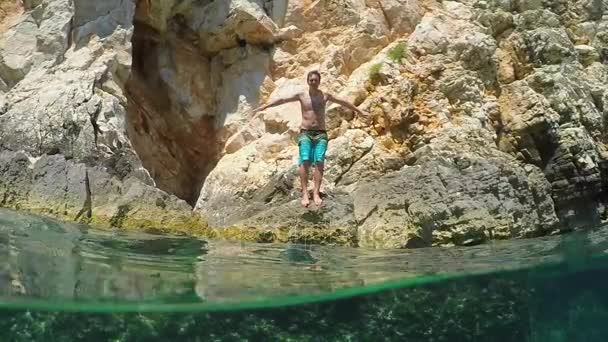 SLOW MOTION UNDERWATER: Hombre buceando de cabeza en el agua y nada bajo la cámara — Vídeo de stock