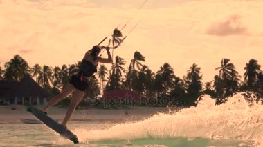 Ağır çekim portre: golden sunset mitingde atlama aşırı kiter kız kiteboard