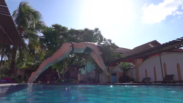 CERRAR: Hermosa mujer joven saltando en la cabeza de la piscina de lujo primero — Vídeo de stock