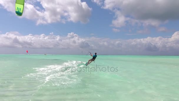 CLOSE UP: Young kiter woman doing the kiting water start and kite surfs away — Stock Video