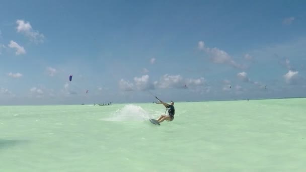 Slow Motion: Jonge kiter vrouw kiteboard springen in de prachtige lagune van Zanzibar — Stockvideo