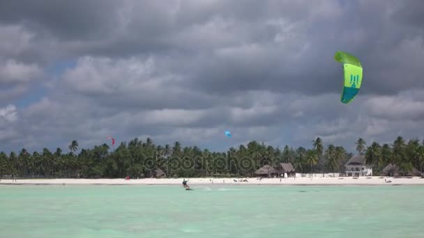 Vrouwelijke kiteboarder vliegeren in perfecte blauwe lagune aan exotische zandstrand — Stockvideo