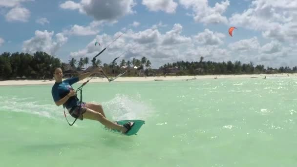 Slow Motion: Glimlachen jonge surfer vrouw kiteboarding in prachtige blauwe lagune — Stockvideo