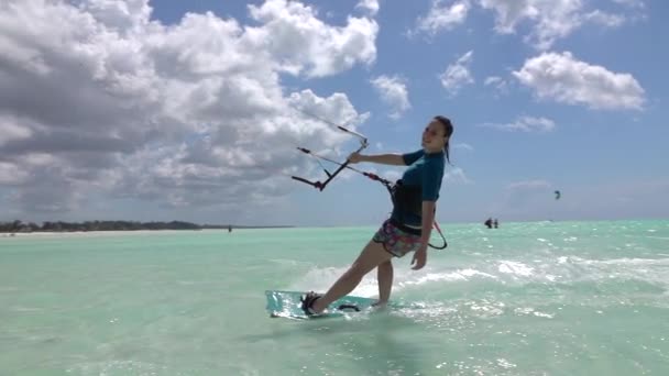 LOW MOTION: Happy surfista menina kiteboarding passado a câmera na bela lagoa — Vídeo de Stock