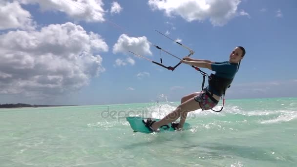 Lassú mozgás: Boldog mosolygó szörfös lány, szórakoztató kitesurfing kék óceán — Stock videók