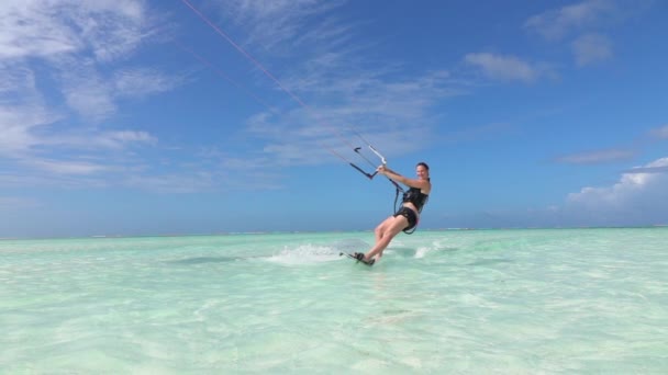 SLOW MOTION: Happy sorrindo surfe menina kitesurfing na superfície do oceano bonito — Vídeo de Stock