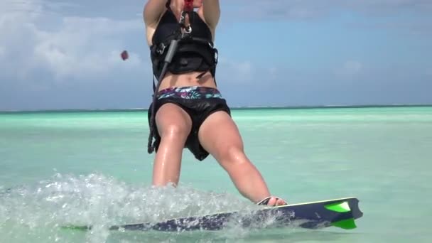 CERRADO DE MOCIÓN LENTA: Kitesurfer joven kiteboarding femenino en laguna azul — Vídeos de Stock