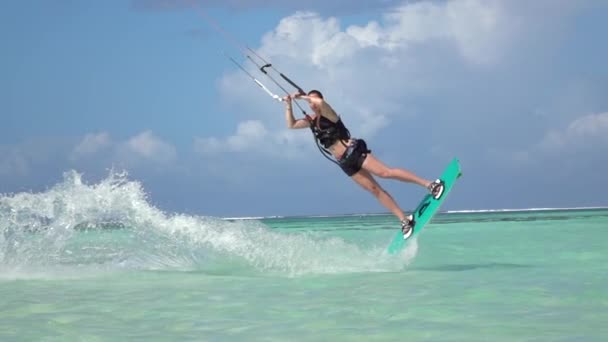 슬로우 모션 근접 촬영: 젊은 서퍼 여자 kiteboard 블루 오션에서 집회를 점프 — 비디오