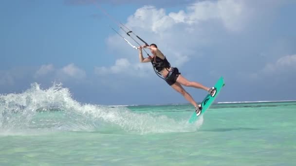 Zwolnionym tempie zbliżenie: Kiteboard dziewczyna Surfera młodych skoki na wiecu w blue ocean — Wideo stockowe